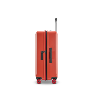 Sicherheit auf Reisen: Seitenansicht des BUZZ Trolleys in Rosso Clay, Größe M, mit dem integrierten, flachen TSA-Zahlenschloss und dem ergonomischen Tragegriff
